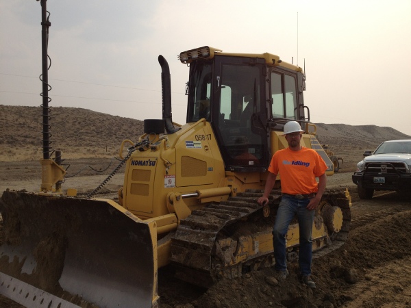worker standing next to bulldozer
